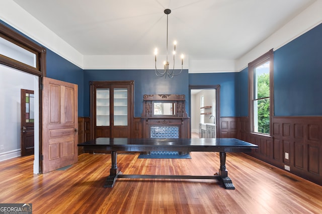 unfurnished dining area with hardwood / wood-style floors and an inviting chandelier