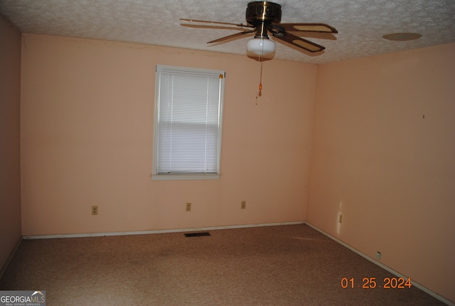 carpeted empty room featuring ceiling fan and a textured ceiling