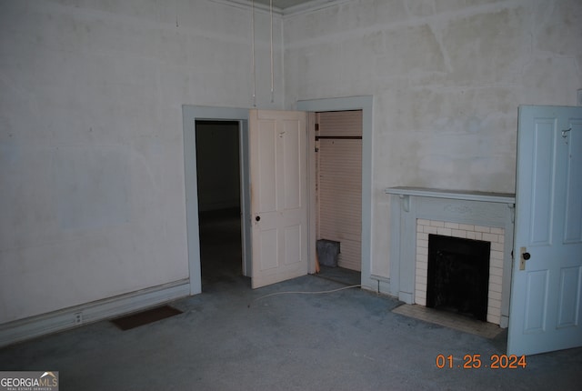 unfurnished living room featuring a brick fireplace and carpet