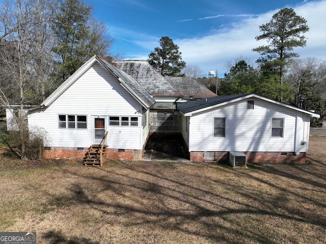 back of property with central AC unit and a lawn