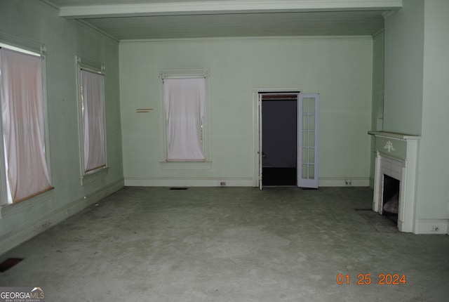 unfurnished living room with ornamental molding, light colored carpet, and beam ceiling