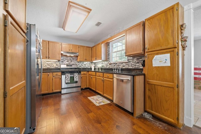 kitchen featuring dark hardwood / wood-style floors, appliances with stainless steel finishes, sink, and a textured ceiling