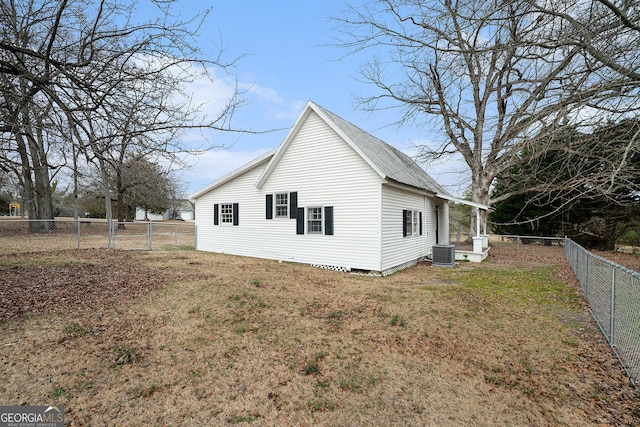 view of side of home featuring a yard and central AC unit