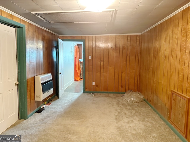 interior space with heating unit, ornamental molding, wooden walls, and light carpet