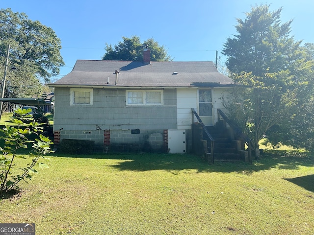 rear view of house featuring a lawn