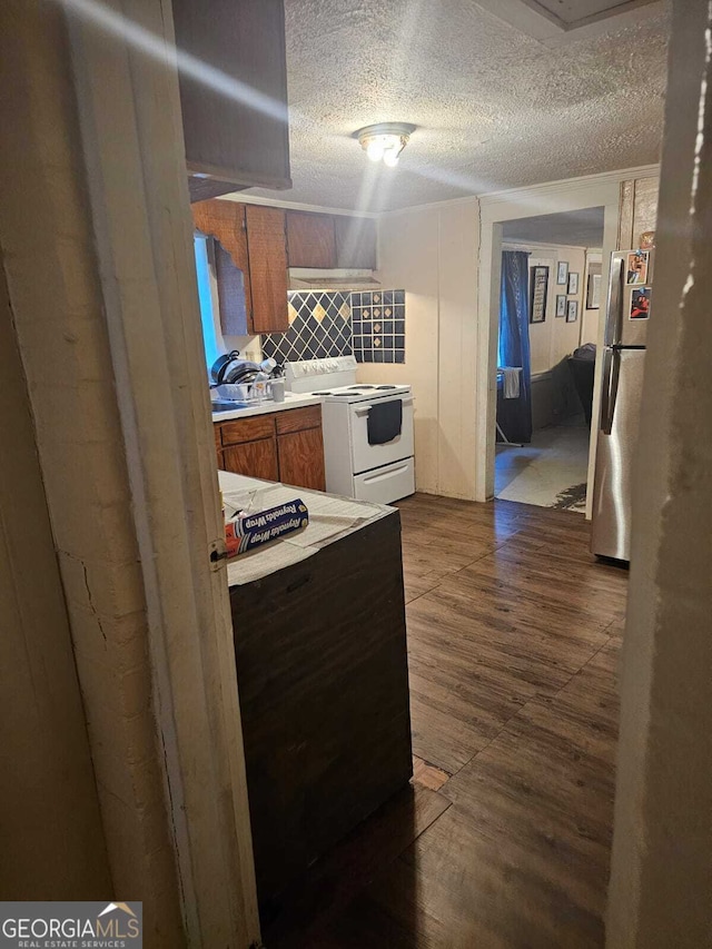 kitchen with backsplash, a textured ceiling, white electric range, stainless steel refrigerator, and dark hardwood / wood-style floors