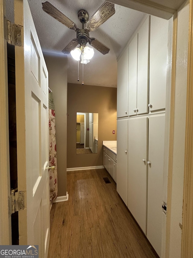 hall featuring light hardwood / wood-style floors and a textured ceiling