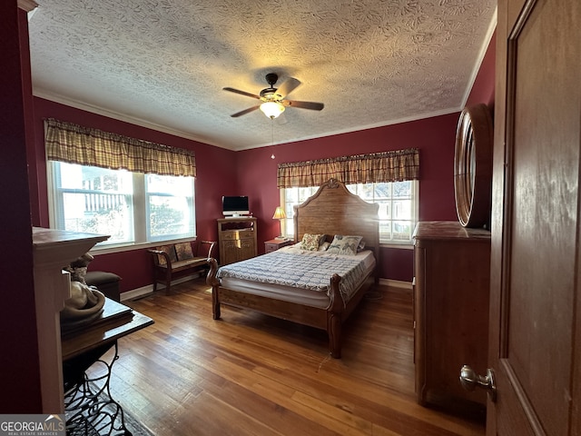 bedroom with ornamental molding, a textured ceiling, wood-type flooring, and ceiling fan