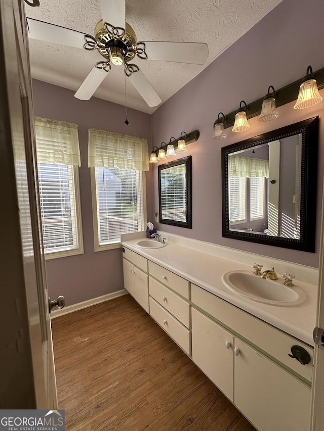 bathroom featuring vanity, a textured ceiling, hardwood / wood-style flooring, and ceiling fan