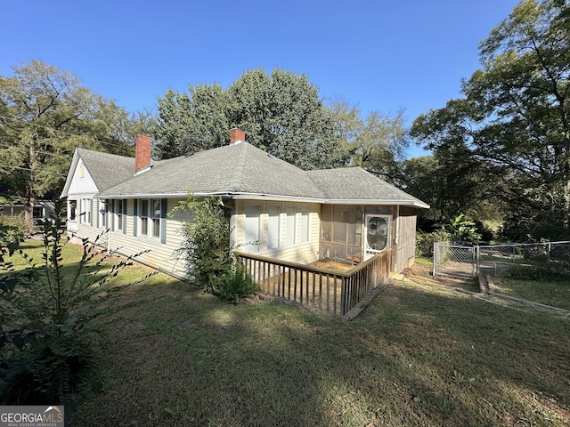 view of home's exterior with a yard and a sunroom