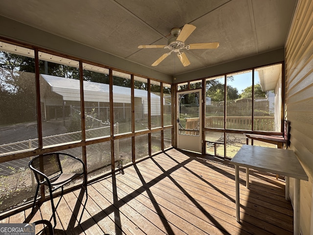 unfurnished sunroom featuring ceiling fan