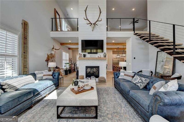 living room with a fireplace, hardwood / wood-style floors, and a high ceiling