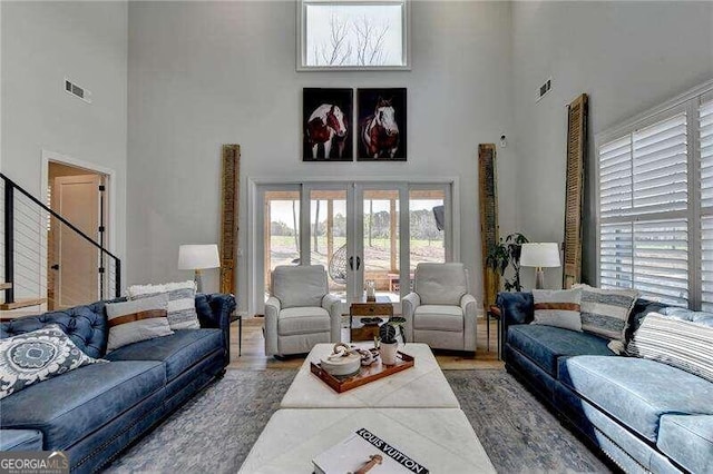 living room featuring french doors, a high ceiling, and hardwood / wood-style flooring