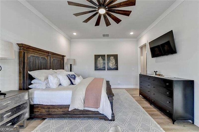 bedroom featuring ceiling fan, crown molding, and light hardwood / wood-style flooring