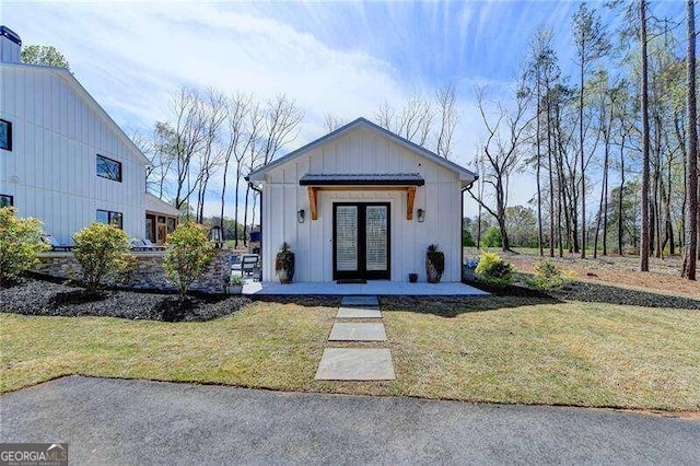 modern farmhouse style home featuring french doors and a front yard