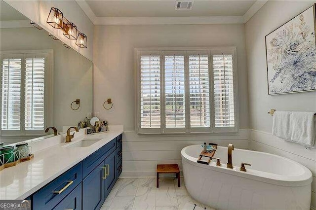 bathroom with vanity, crown molding, and a tub