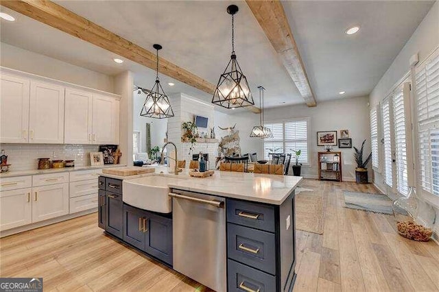 kitchen with dishwasher, sink, light hardwood / wood-style flooring, decorative light fixtures, and white cabinets