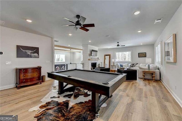 rec room with a large fireplace, light hardwood / wood-style floors, ceiling fan, and billiards