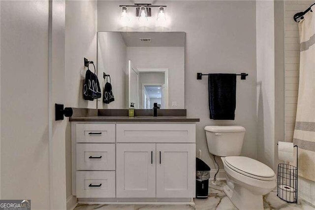 bathroom featuring vanity, toilet, and curtained shower