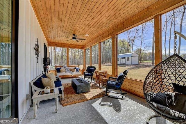 sunroom featuring ceiling fan, a healthy amount of sunlight, and wood ceiling