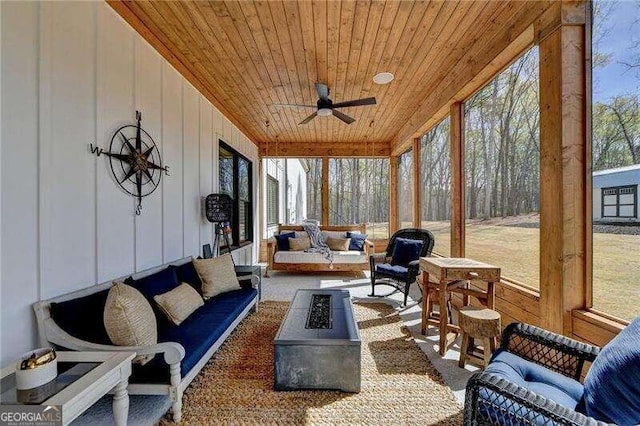 sunroom / solarium featuring ceiling fan, wooden ceiling, and a wealth of natural light