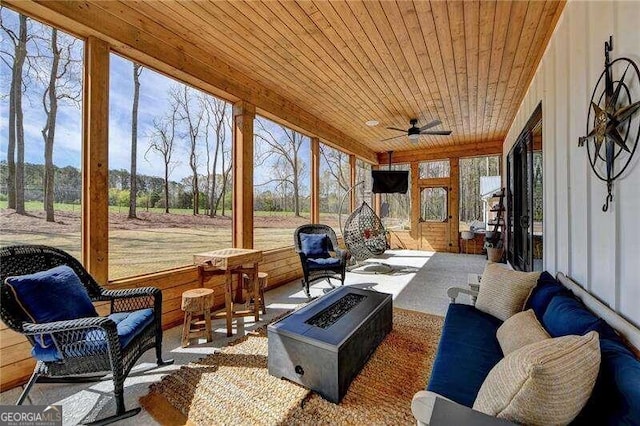 sunroom with ceiling fan and wood ceiling