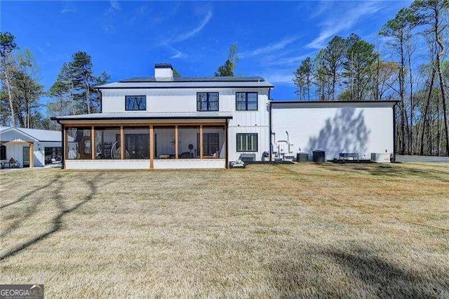 back of house featuring a sunroom and a yard