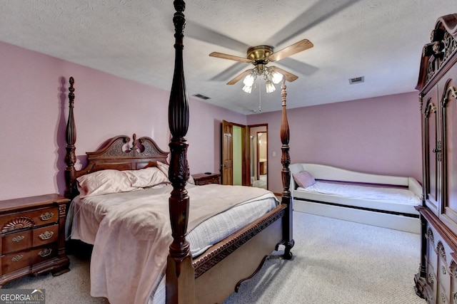 carpeted bedroom with a textured ceiling and ceiling fan