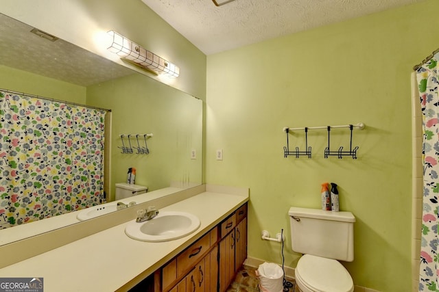 bathroom with vanity, a textured ceiling, and toilet