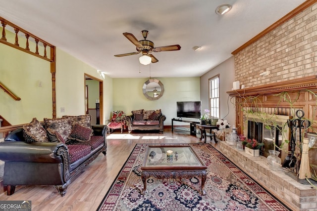 living room with ceiling fan, light hardwood / wood-style floors, and a fireplace