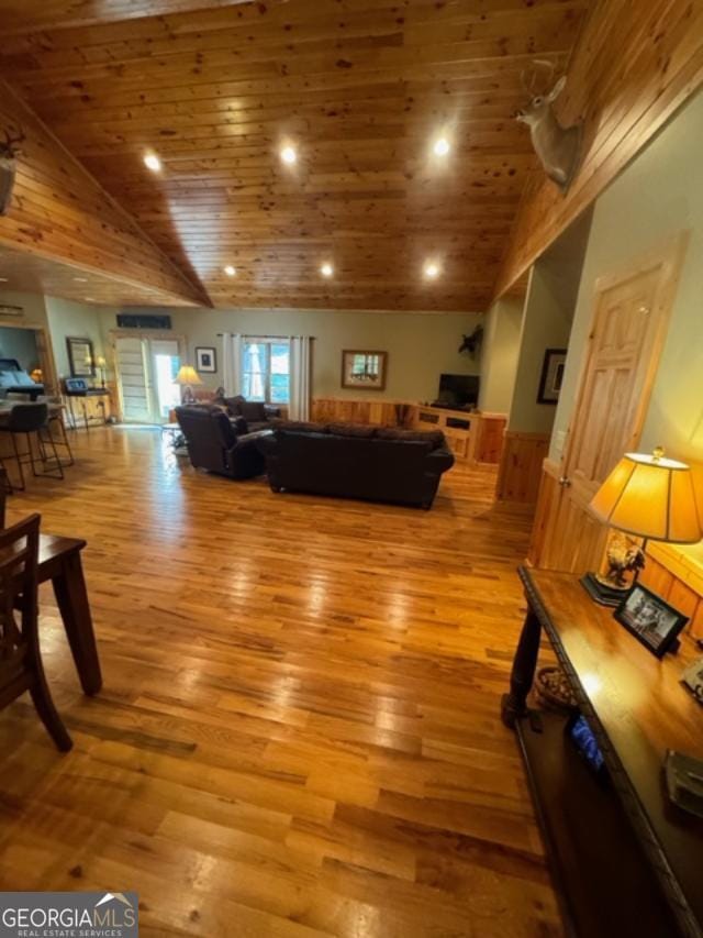 living room featuring wooden ceiling, high vaulted ceiling, and light hardwood / wood-style flooring