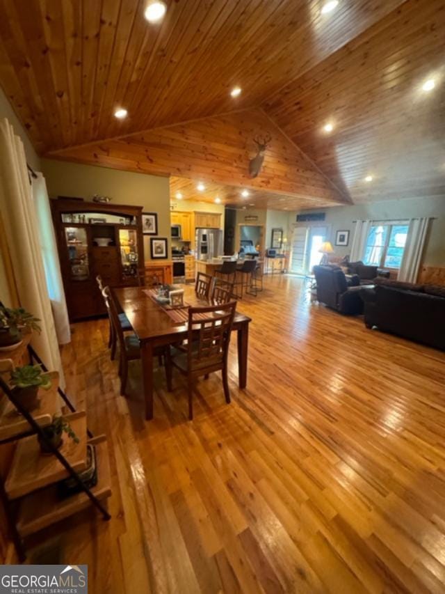 dining space with wooden ceiling, high vaulted ceiling, and light wood-type flooring