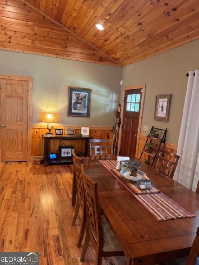 dining room with lofted ceiling, hardwood / wood-style floors, and wood ceiling