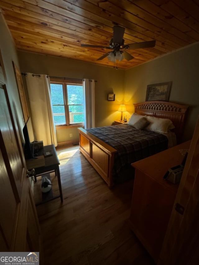 bedroom featuring ceiling fan, wood ceiling, and dark hardwood / wood-style flooring