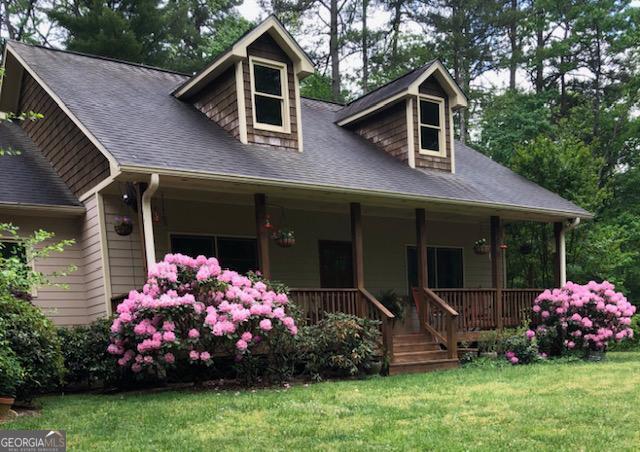 cape cod house with a porch and a front yard