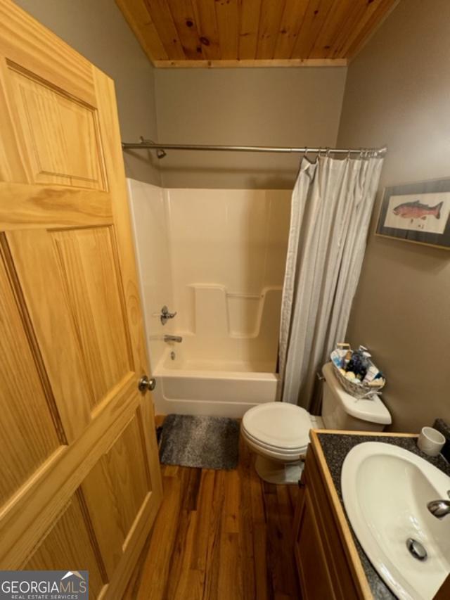 full bathroom featuring wooden ceiling, shower / bath combo, vanity, and toilet