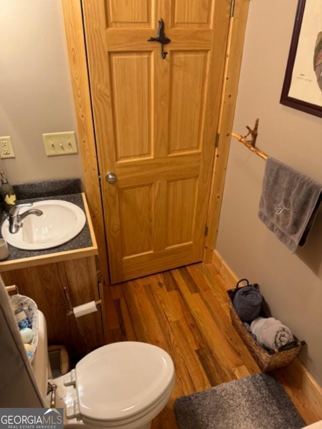 bathroom with vanity, hardwood / wood-style floors, and toilet