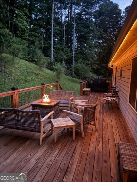 wooden terrace with an outdoor fire pit