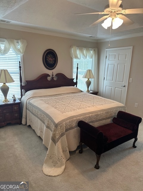 carpeted bedroom with ornamental molding, multiple windows, ceiling fan, and a textured ceiling