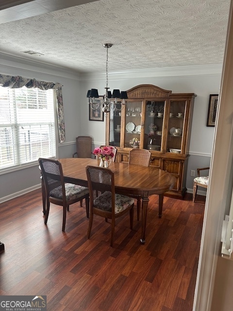 dining space with a textured ceiling, dark hardwood / wood-style floors, a chandelier, and crown molding