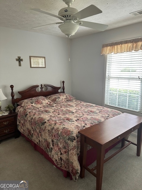 carpeted bedroom with a textured ceiling and ceiling fan