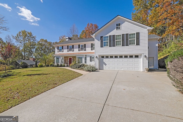 view of property with a garage and a front lawn