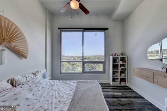 bedroom featuring ceiling fan, dark hardwood / wood-style flooring, and multiple windows