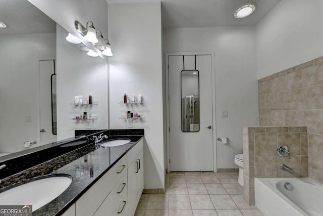 bathroom featuring vanity, a bathtub, tile patterned flooring, and toilet