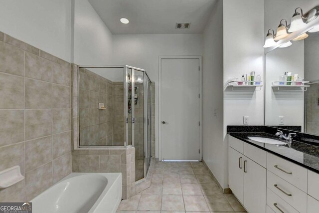 bathroom with tile patterned flooring, plus walk in shower, and vanity