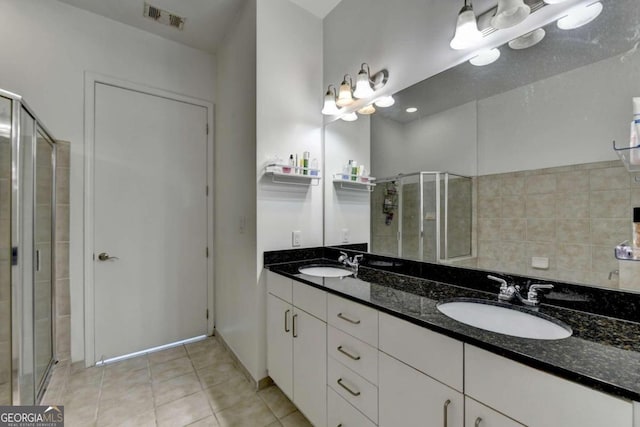 bathroom featuring tile patterned flooring, vanity, and a shower with shower door