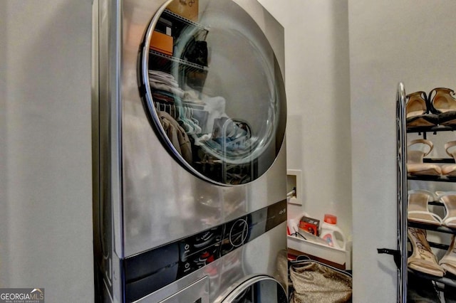 clothes washing area featuring stacked washer and clothes dryer