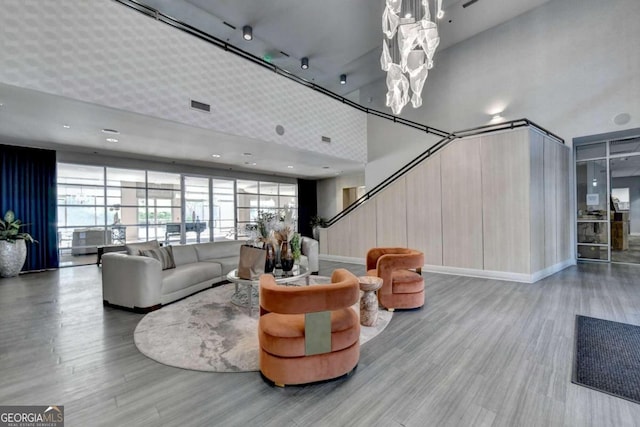 living room featuring a towering ceiling and light hardwood / wood-style floors