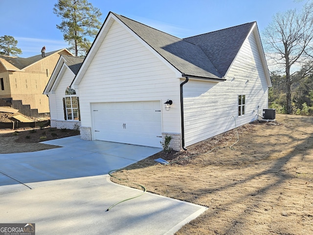 view of side of property with central AC unit and a garage