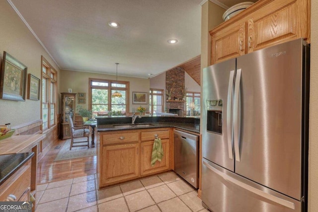 kitchen with hanging light fixtures, ornamental molding, sink, kitchen peninsula, and stainless steel appliances